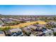 Expansive aerial view of a well-planned community with green spaces and mountain views in the distance at 27621 N 174Th Dr, Surprise, AZ 85387