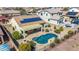 Aerial view of a backyard featuring a pool, patio, lush landscaping, and solar panels for sustainable living at 27621 N 174Th Dr, Surprise, AZ 85387