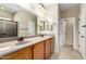 Bathroom features a double sink vanity, granite countertops, decorative mirrors, and shower with sliding glass doors at 27621 N 174Th Dr, Surprise, AZ 85387