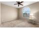 Bedroom with a large window, ceiling fan, and neutral carpet at 27621 N 174Th Dr, Surprise, AZ 85387