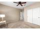 Bedroom featuring neutral carpet, a ceiling fan, and double door closet at 27621 N 174Th Dr, Surprise, AZ 85387