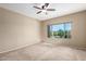 Spacious bedroom features neutral walls, carpeted floors, and a window overlooking the manicured yard at 27621 N 174Th Dr, Surprise, AZ 85387