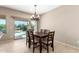 Well-lit dining room featuring a modern chandelier and sliding glass door with a view to the backyard and pool at 27621 N 174Th Dr, Surprise, AZ 85387