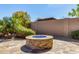 Charming backyard fire pit area with a stacked stone surround, ideal for cozy evenings outdoors at 27621 N 174Th Dr, Surprise, AZ 85387