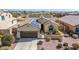 Single-story home features solar panels, three-car garage, and desert landscaping in front yard at 27621 N 174Th Dr, Surprise, AZ 85387
