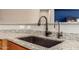 Close-up shot of deep kitchen sink with granite countertops and a view into the living area at 27621 N 174Th Dr, Surprise, AZ 85387