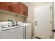 Laundry room featuring modern washer and dryer machines and above storage cabinets at 27621 N 174Th Dr, Surprise, AZ 85387