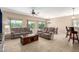 Spacious living room with tile floors, ceiling fan, and comfortable reclining sofas at 27621 N 174Th Dr, Surprise, AZ 85387