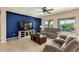 Comfortable living room boasts a large screen TV, plush seating, and view to the sparkling blue pool outdoors at 27621 N 174Th Dr, Surprise, AZ 85387