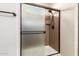 Shower featuring bronze hardware, a partial glass door, and a built-in corner shelf at 27621 N 174Th Dr, Surprise, AZ 85387