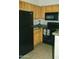 Efficient kitchen showcasing wood cabinets, granite countertops, and modern black appliances at 2929 W Yorkshire Dr # 1028, Phoenix, AZ 85027