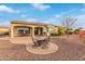 An inviting outdoor patio with dining table and chairs sits on brick pavers with desert landscaping at 30056 N 129Th Ave, Peoria, AZ 85383