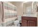 Bathroom featuring a white toilet and sink with a colorful striped shower curtain at 30056 N 129Th Ave, Peoria, AZ 85383