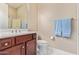 Bathroom with a dark wood vanity, white countertop, and a mirror, complemented by blue towels at 30056 N 129Th Ave, Peoria, AZ 85383