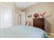 Cozy bedroom with a blue striped bedspread, dark wood dresser, and a neutral color scheme at 30056 N 129Th Ave, Peoria, AZ 85383