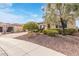 A home's exterior showcases desert landscaping, a driveway, and a well-maintained lawn at 30056 N 129Th Ave, Peoria, AZ 85383