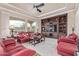 Bright living room featuring a ceiling fan, stone tile floors and built-in shelving at 30056 N 129Th Ave, Peoria, AZ 85383