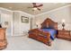 A spacious main bedroom boasts an ornate, dark-wood bed frame and neutral carpeting at 30056 N 129Th Ave, Peoria, AZ 85383