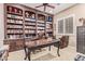 Home office featuring custom built-in wood bookshelves, a desk, and a leather chair at 30056 N 129Th Ave, Peoria, AZ 85383