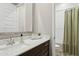 Bright bathroom with a modern vanity, quartz countertop, and tiled shower with a curtain at 31489 N 126Th Ln, Peoria, AZ 85383