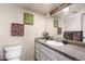 Neat half bathroom featuring a speckled countertop, stylish decor, and a convenient toilet at 3429 W Aire Libre Ave, Phoenix, AZ 85053