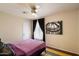 Bright bedroom featuring a ceiling fan, and a decorative art piece above the bed at 3429 W Aire Libre Ave, Phoenix, AZ 85053