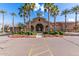 Elegant clubhouse entrance with tall palm trees, manicured landscaping, and a grand arched entryway at 3749 E Riopelle Ave, Gilbert, AZ 85298