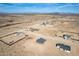 Wide aerial view of the homes in a desert community with green farms in the distance at 37691 W Vermont Ave, Tonopah, AZ 85354