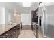 Open concept kitchen with granite countertops, stainless steel appliances, and dark wood cabinetry at 4808 N 24Th St # 925, Phoenix, AZ 85016