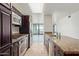 Galley kitchen features stainless steel appliances, brown cabinets, tile flooring, and granite countertops at 4808 N 24Th St # 925, Phoenix, AZ 85016
