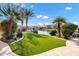 Landscaped backyard featuring lush green lawn, tropical trees, and waterfront access at 4862 S Jojoba Way, Chandler, AZ 85248