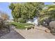 Landscaped backyard featuring a well-maintained lawn, stone bench, mature trees, and a charming gazebo at 5478 E Oakhurst Way, Scottsdale, AZ 85254
