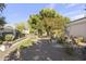 Backyard garden area with gravel pathway, mature trees, landscaping and various decorative elements at 5478 E Oakhurst Way, Scottsdale, AZ 85254