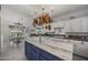 Bright kitchen with marble island, pot rack and white cabinets offers a practical and stylish space at 5478 E Oakhurst Way, Scottsdale, AZ 85254