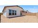 A large backyard with dirt and a covered patio connected to the house at 550 E Aurora Dr, San Tan Valley, AZ 85140