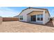 A large backyard with dirt and a covered patio connected to the house at 550 E Aurora Dr, San Tan Valley, AZ 85140