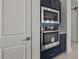 Built-in stainless steel oven and microwave combination nestled between the navy blue kitchen cabinets at 550 E Aurora Dr, San Tan Valley, AZ 85140