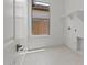 Laundry Room with white walls, tile flooring and a bright window at 550 E Aurora Dr, San Tan Valley, AZ 85140