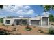 Modern home featuring a stone facade, desert landscaping, and a three-car garage at 7195 E Rancho Del Oro Dr, Scottsdale, AZ 85266