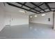 Spacious three-car garage with epoxy floors, white walls, and automatic door openers at 7195 E Rancho Del Oro Dr, Scottsdale, AZ 85266