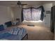Bedroom featuring neutral walls, ceiling fan and natural light from a large window at 7617 E Thunderbird Rd, Scottsdale, AZ 85260