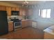 Kitchen with wood cabinets, black appliances, and tile flooring at 7617 E Thunderbird Rd, Scottsdale, AZ 85260