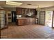 View of kitchen with stainless steel appliances, dark wood cabinets, and tiled flooring at 7617 E Thunderbird Rd, Scottsdale, AZ 85260