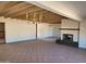 Open living room with beamed ceilings, red-tiled floors, and fireplace at 7617 E Thunderbird Rd, Scottsdale, AZ 85260