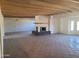 Spacious living room featuring a brick fireplace, tiled flooring and beamed ceilings at 7617 E Thunderbird Rd, Scottsdale, AZ 85260