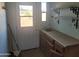 Mud room with utility sink, shelves, and outdoor access door at 7617 E Thunderbird Rd, Scottsdale, AZ 85260