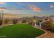 Landscaped backyard boasts vibrant greenery, a desert garden, and serene seating areas against a scenic mountain backdrop at 11036 E Evans Rd, Scottsdale, AZ 85255