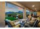 Expansive covered patio area with comfortable seating and stunning views of the lush backyard and distant mountains at 11036 E Evans Rd, Scottsdale, AZ 85255