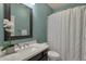 Well-lit bathroom with decorative mirror, white shower curtain, and flowers at 11036 E Evans Rd, Scottsdale, AZ 85255