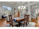 Elegant dining room with wood table, seating for six, bright windows, and an open view to the living room at 11036 E Evans Rd, Scottsdale, AZ 85255